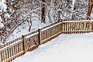 Wooden backyard fence of house with snow covered ground