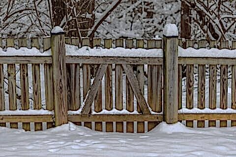 wooden fence covered in snow