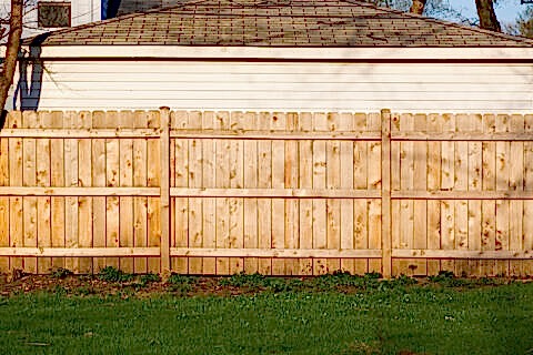 A hard wood fence outside a house